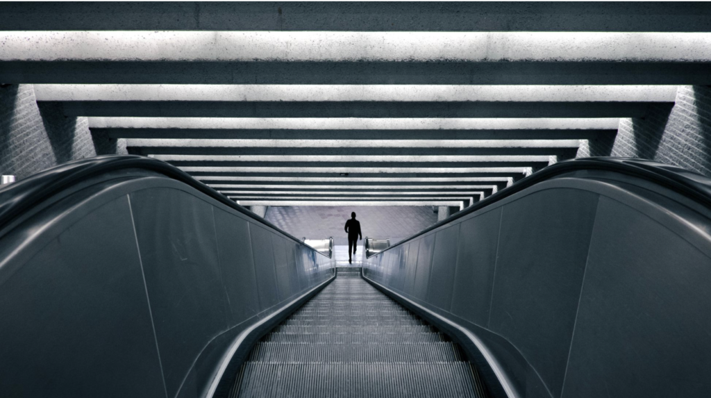 long escalator with man walking off bottom