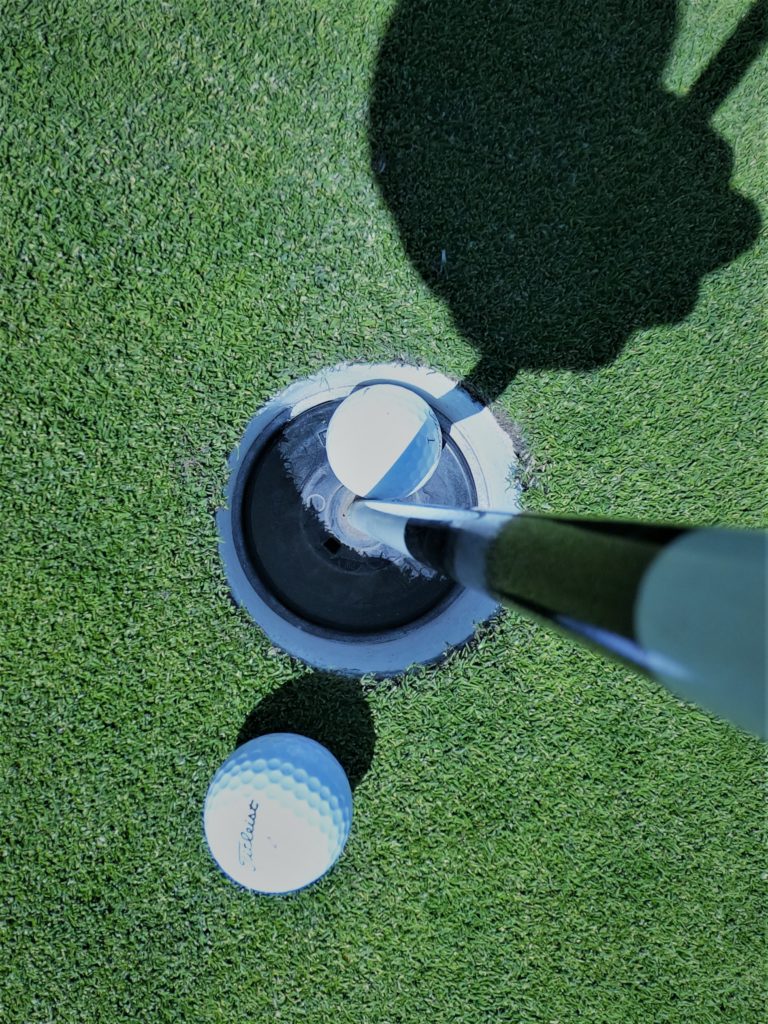 looking down at golf ball in hole