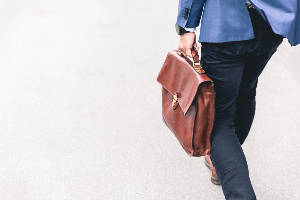man carrying leather briefcase