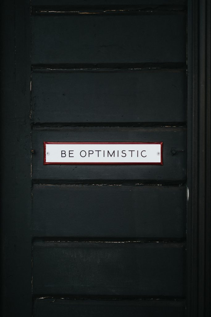 sign that says be optimistic